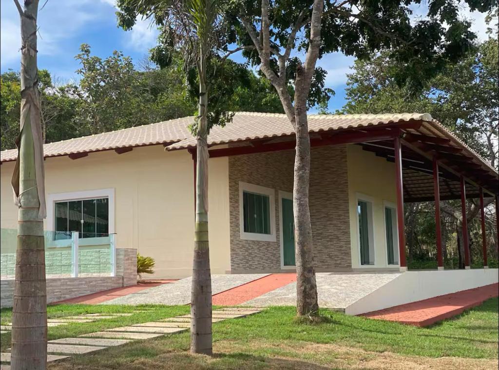 una casa con dos palmeras delante de ella en Area de Lazer fazenda Papuã- Lugar de PAZ, en Caldas Novas