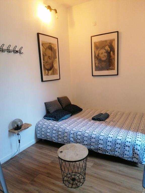 - 2 lits dans une chambre avec 2 photos sur le mur dans l'établissement Studio centre ville st aubin, à Toulouse