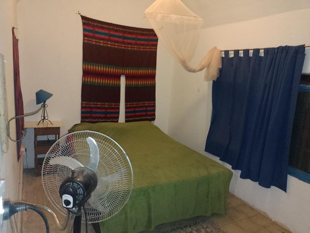 a room with a fan in a room with a window at Sonqo Wasi in San Marcos Sierras
