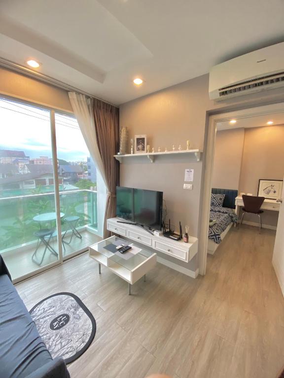 a living room with a tv and a large window at Lucky Lucky Chill in Chon Buri