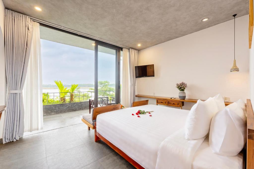 Postel nebo postele na pokoji v ubytování Serene Riverside Hotel Hoi An