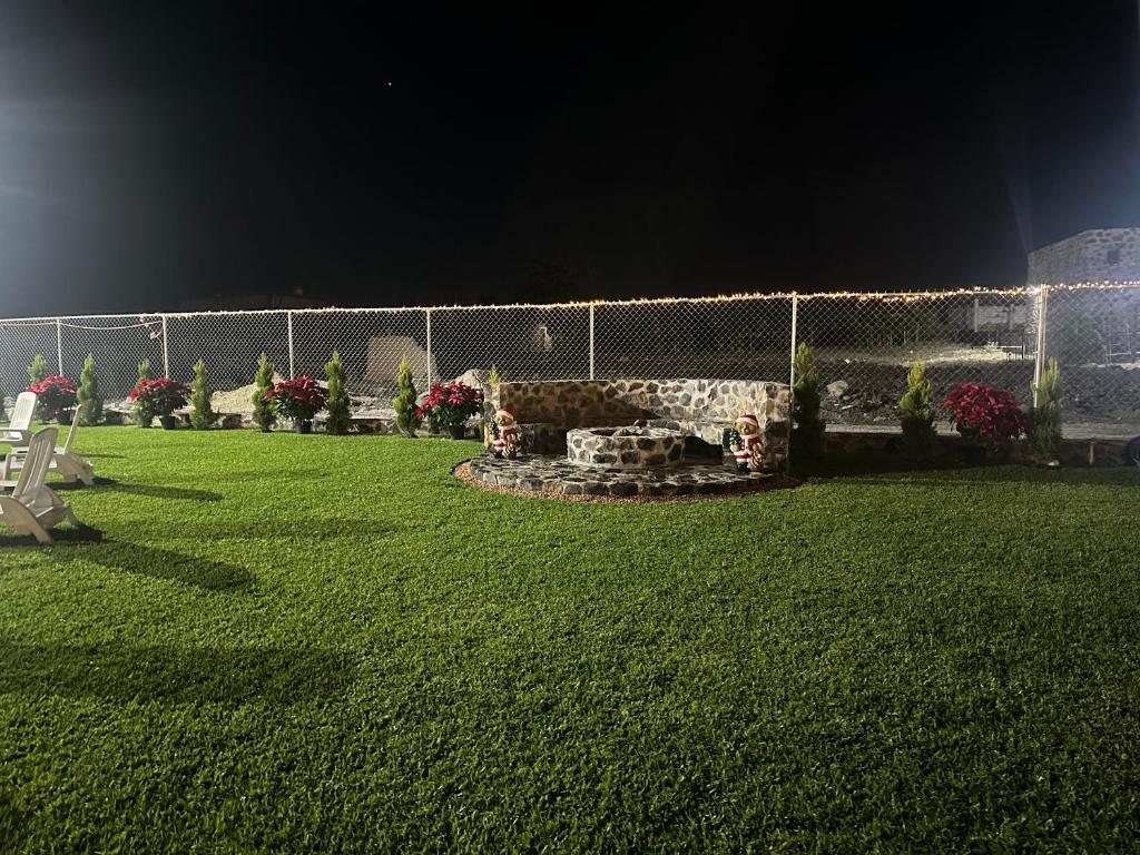 una recinzione con buca per il fuoco in un cortile di notte di Rancho MM a Temixco