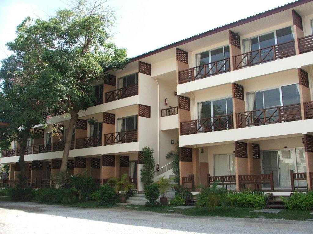 ein Apartmenthaus mit Balkon und einem Baum in der Unterkunft Cha Am Villa Beach in Ban Bo Khaem
