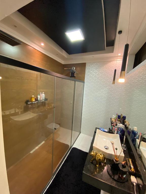 a bathroom with a glass shower and a sink at Casa luxo ferias in Porto Seguro