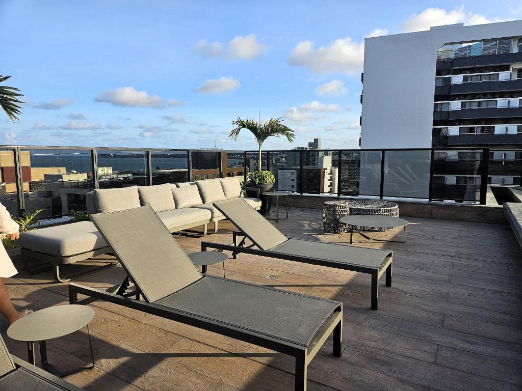 a balcony with chairs and tables on a building at Lindo Studio no Coração de Tambaú in João Pessoa