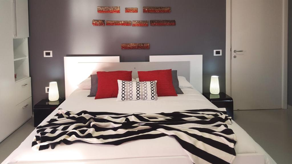 サレルノにあるStone's B&Bのベッドルーム(赤い枕の大きな白いベッド付)