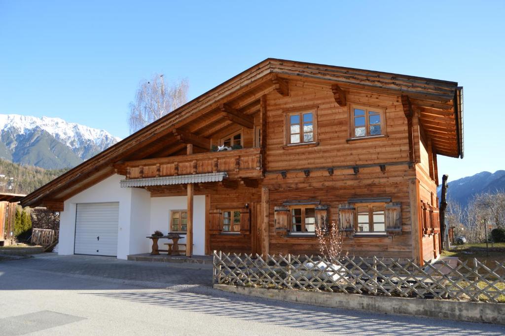a large wooden house with a white garage at Tiroler Blockhaus in Imst