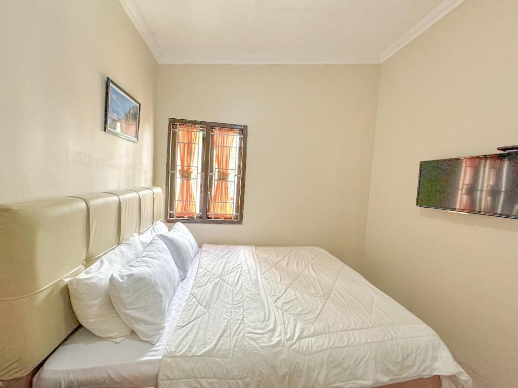 Postel nebo postele na pokoji v ubytování OWK Homestay Mitra RedDoorz Wonosobo