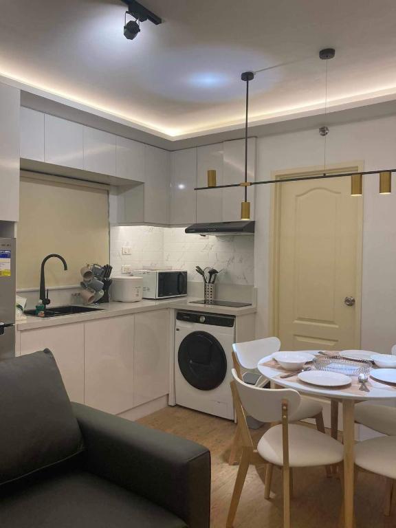 a kitchen and living room with a table and a dining room at Sanremo Oasis Condo in Cebu City