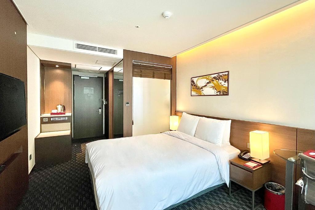 Postel nebo postele na pokoji v ubytování Ramada Encore by Wyndham Busan Station