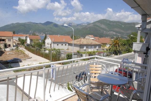 a balcony with a table and chairs and a street at Apartments Dosljak in Tivat