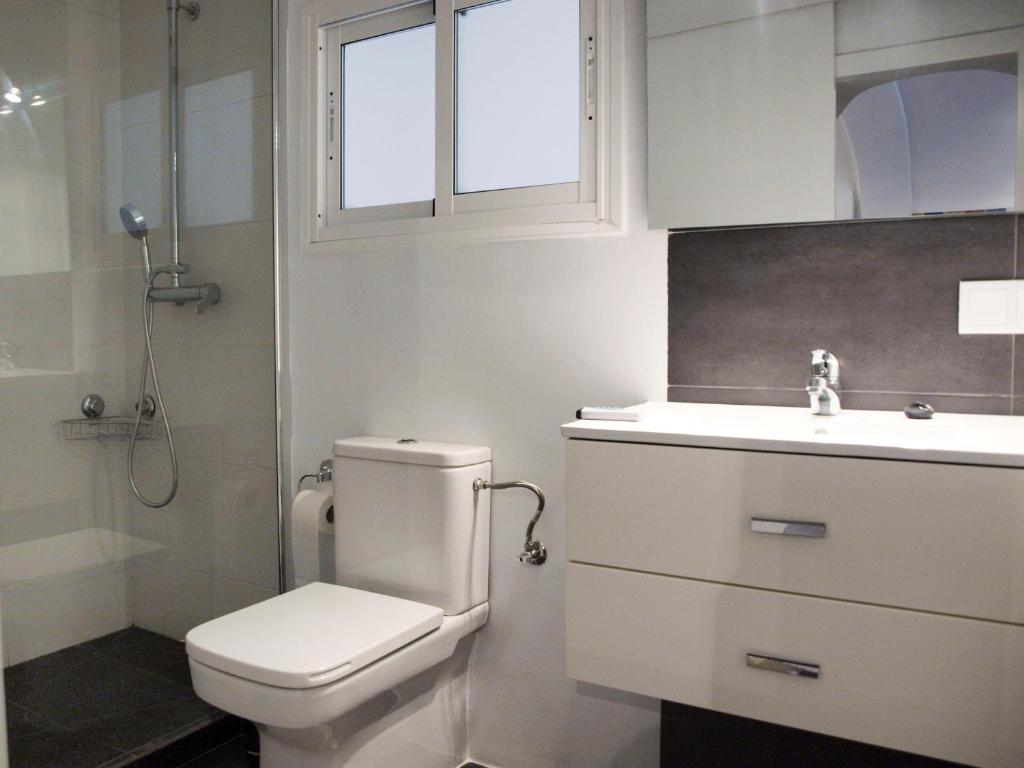 a bathroom with a toilet and a sink and a window at Villa Arcos in Arcos de la Frontera