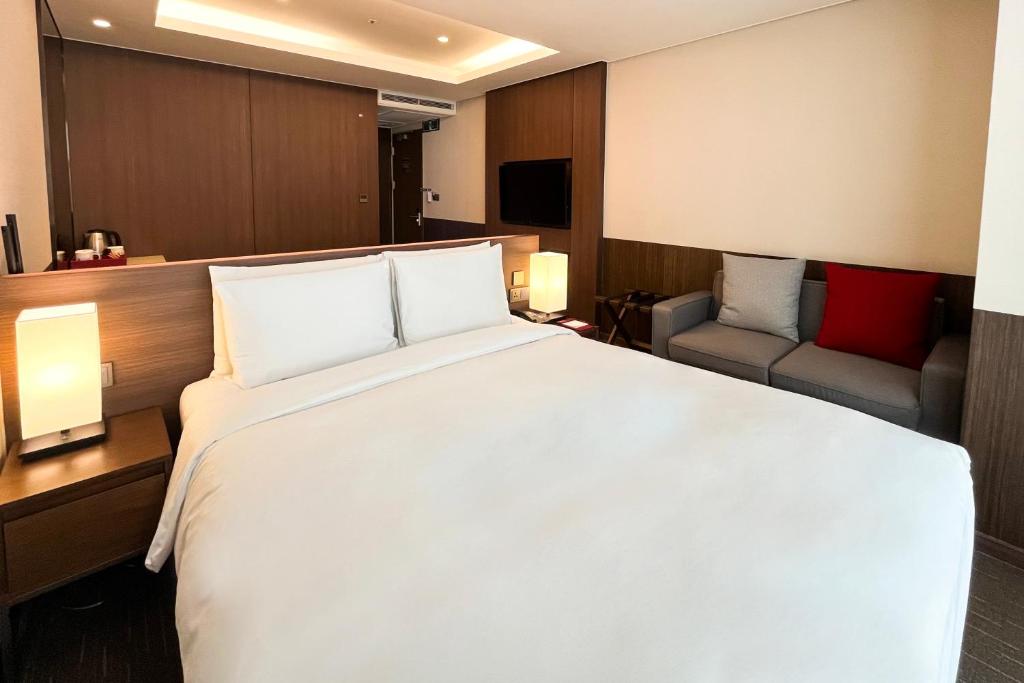 Postel nebo postele na pokoji v ubytování Ramada Encore by Wyndham Busan Station