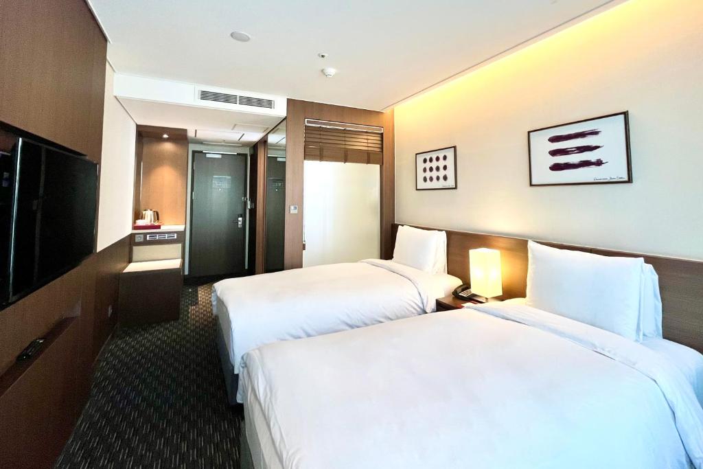 Postel nebo postele na pokoji v ubytování Ramada Encore by Wyndham Busan Station