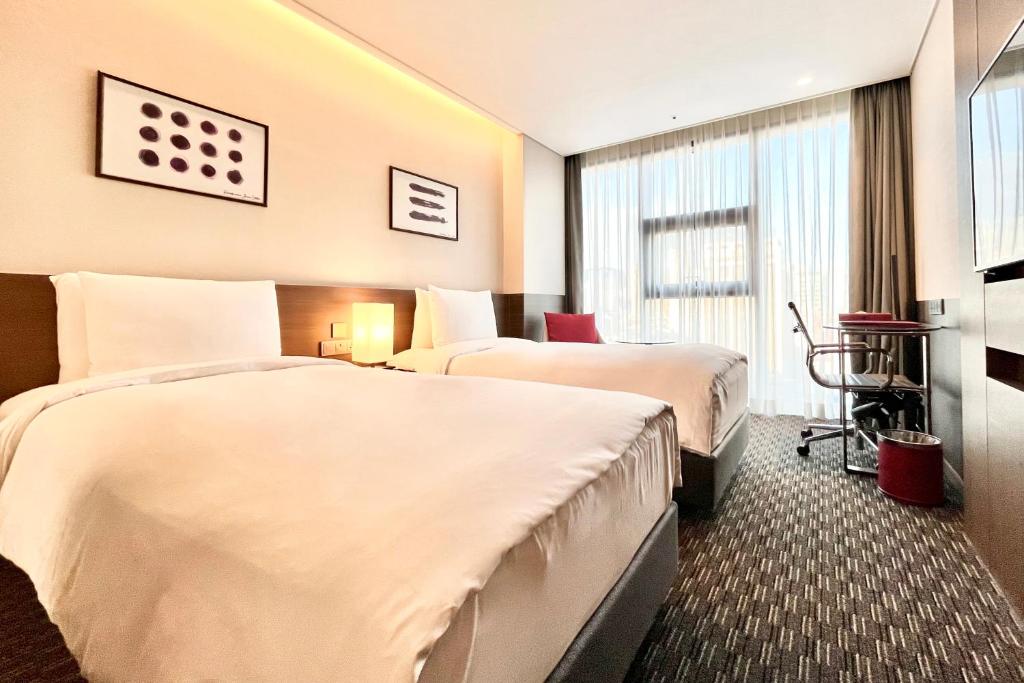 Postel nebo postele na pokoji v ubytování Ramada Encore by Wyndham Busan Station