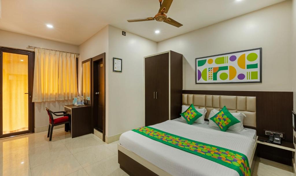 a bedroom with a bed and a desk with a chair at Treebo The Golden Sands, Bistupur in Jamshedpur