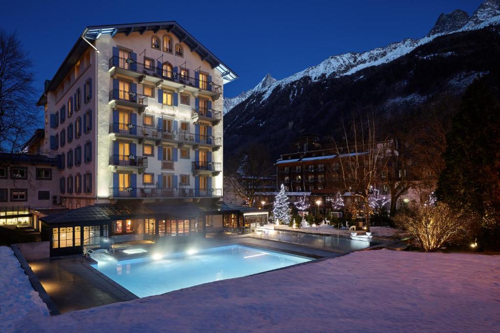 a hotel with a swimming pool in front of a building at Hôtel Mont-Blanc Chamonix in Chamonix