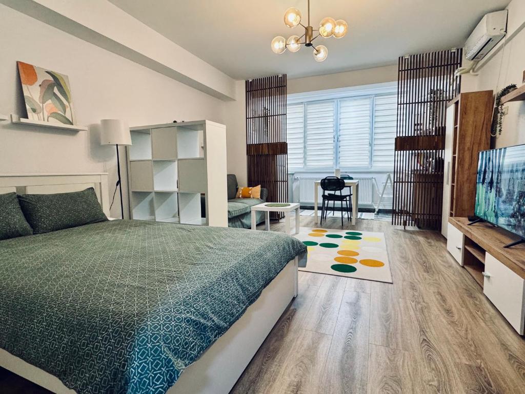 ein Schlafzimmer mit einem Bett, einem Schreibtisch und einem Fernseher in der Unterkunft Altheda Living Zircon A-37 in Suceava