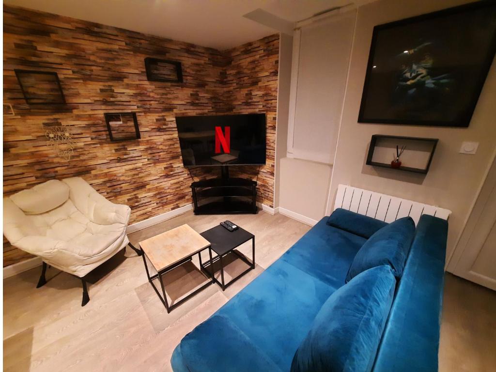 un salon avec un canapé bleu et une cheminée dans l'établissement L'Azur - Apt 4 Prs avec jardin en centre ville, à Dijon