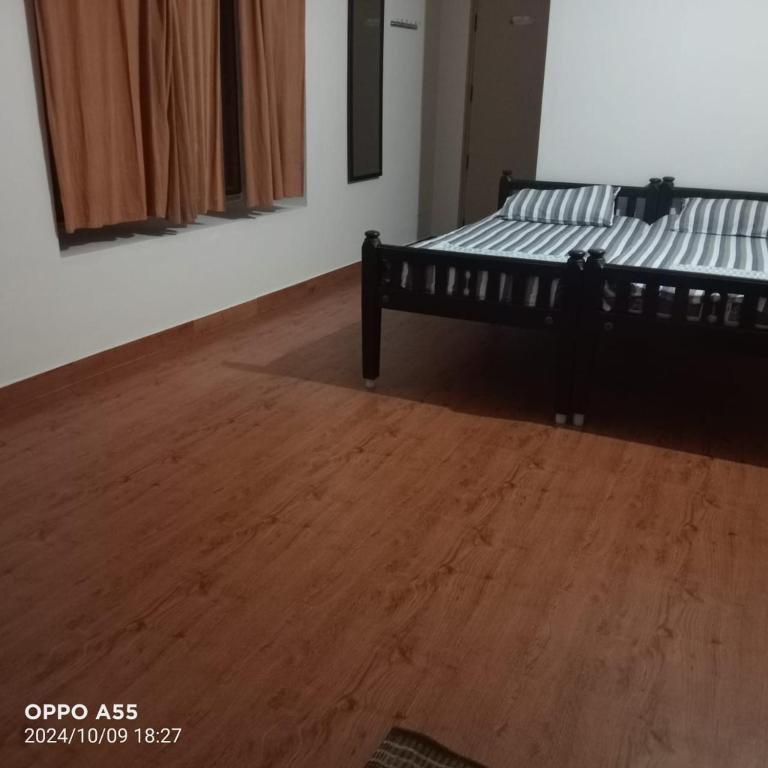 a bedroom with a bed and a wooden floor at Serenity Space in Dānishpet