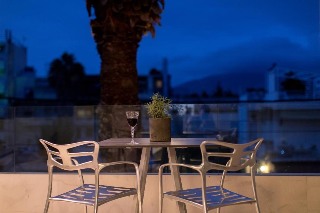 a table with two chairs and a glass of wine at Brasil Suites Boutique Hotel in Athens