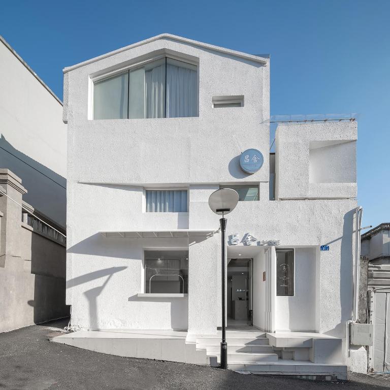 a white house with a street light in front of it at 鼓浪屿吕舍民宿 in Gulang Yu
