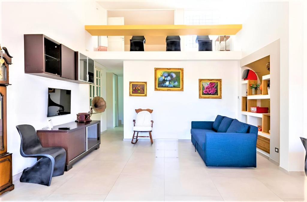 a living room with a blue couch and a chair at Casa Giulù- in Palermo