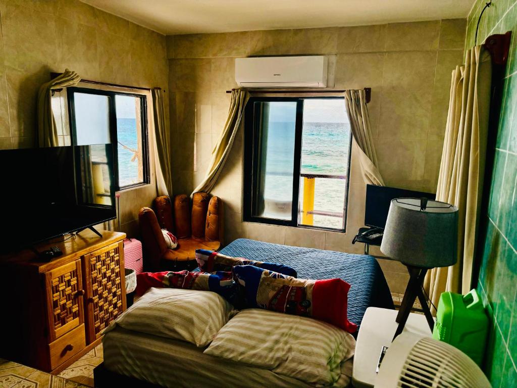 a living room with a bed and a tv and window at Apartment Suite Deluxe Isla Mujeres Sea View Vista al Mar in Isla Mujeres