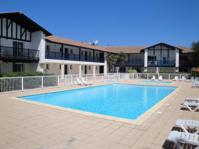 ein großes Schwimmbad vor einem Gebäude in der Unterkunft Appt vue golf dans résidence avec piscine in Bassussarry