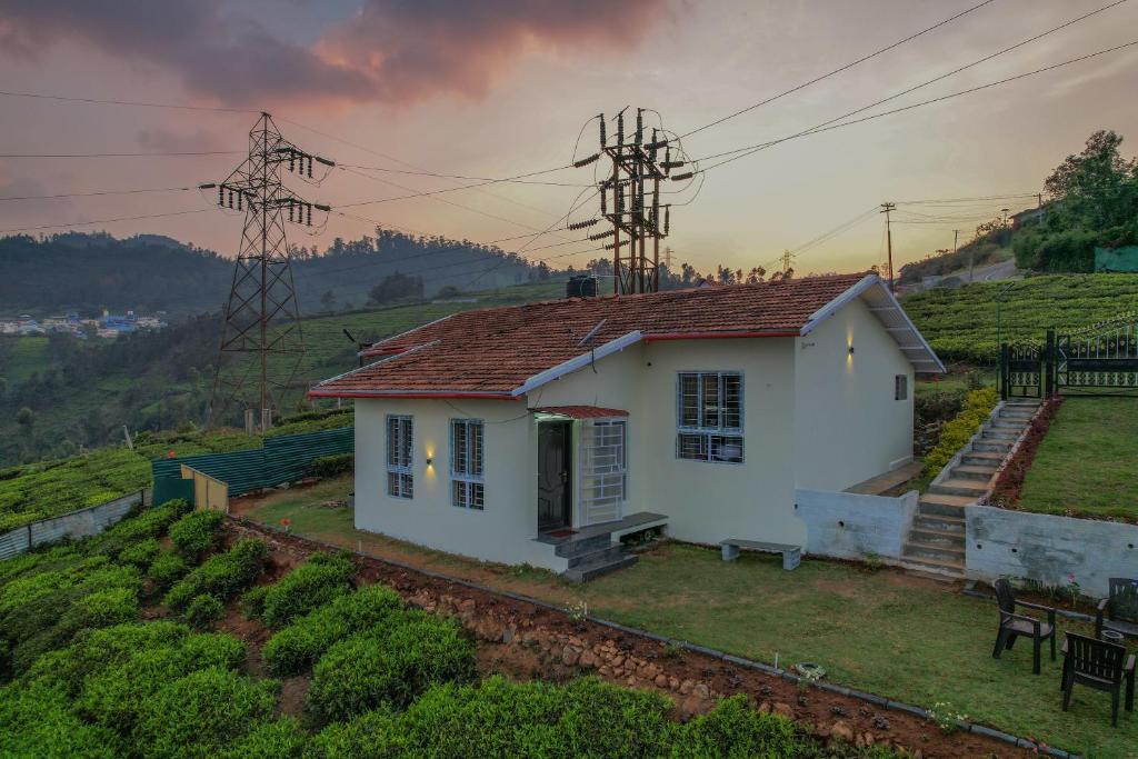 a small white house on top of a hill at The Springs by Indo Stays in Yedapalli