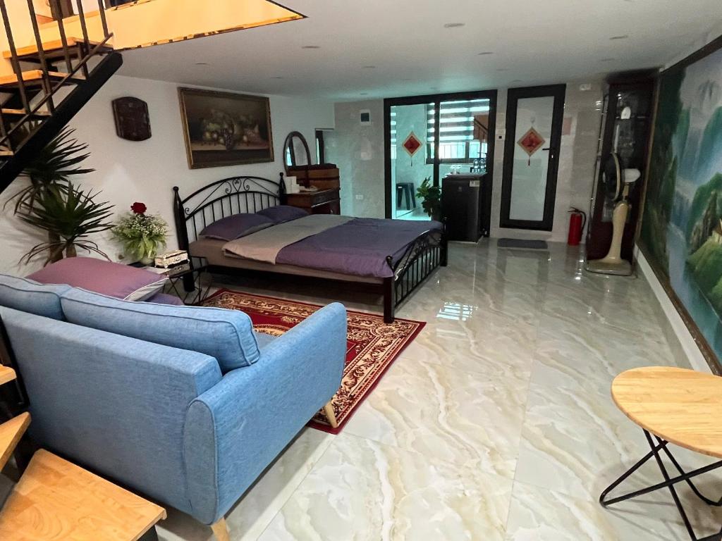 a living room with a bed and a blue couch at Sunny Balcony in Hanoi
