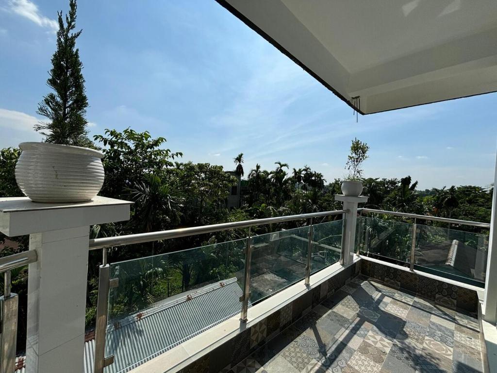 a balcony with two potted plants on top of it at Choudhury's Stay Barpeta Road in Helāpākari