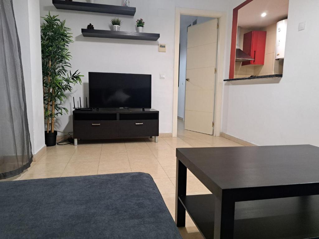 salon z telewizorem i stołem w obiekcie Apartamento Eursu Playa w Maladze