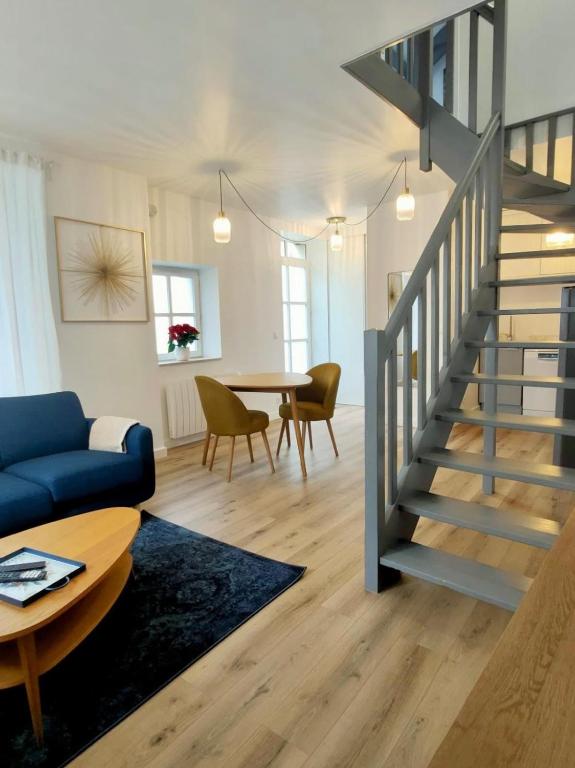 - un salon avec un canapé bleu et un escalier dans l'établissement Petite maison centre-ville, à Nemours