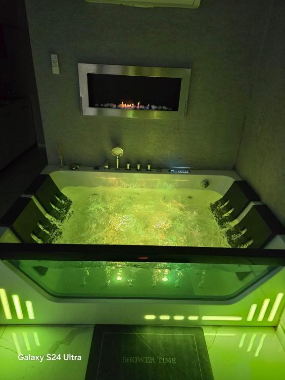 a green bath tub with a fireplace in a room at Apartament Miami in Ełk