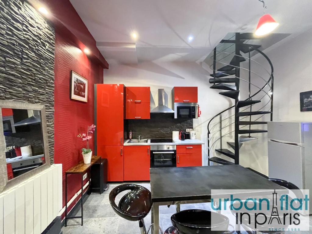 une cuisine avec des placards rouges et un escalier en colimaçon dans l'établissement 21 Atelier Chaplin Montorgueil, à Paris