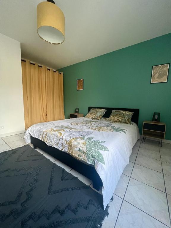 une chambre avec un grand lit et un mur végétal dans l'établissement Le Paisible d'Audincourt, à Audincourt