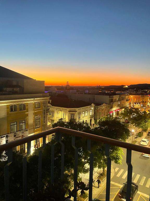 a view of a city at sunset from a balcony at Elegant Apartment Overlooking Historic Loulé in Loulé