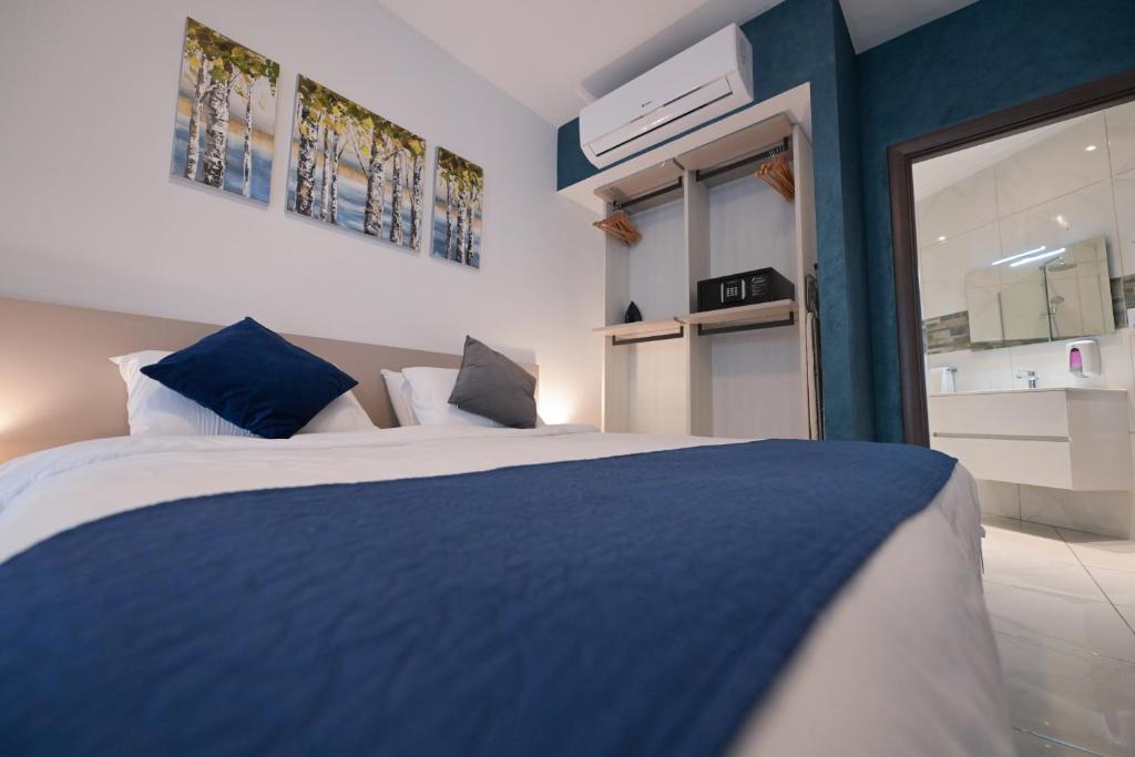a bedroom with a blue and white bed and a window at The Exiles Hotel in Sliema
