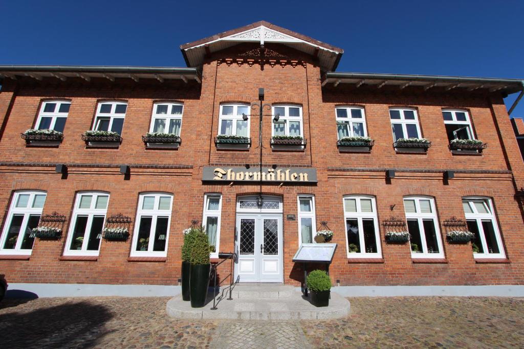 ein rotes Backsteingebäude mit einem Schild darauf in der Unterkunft Hotel Thormählen in Lübeck