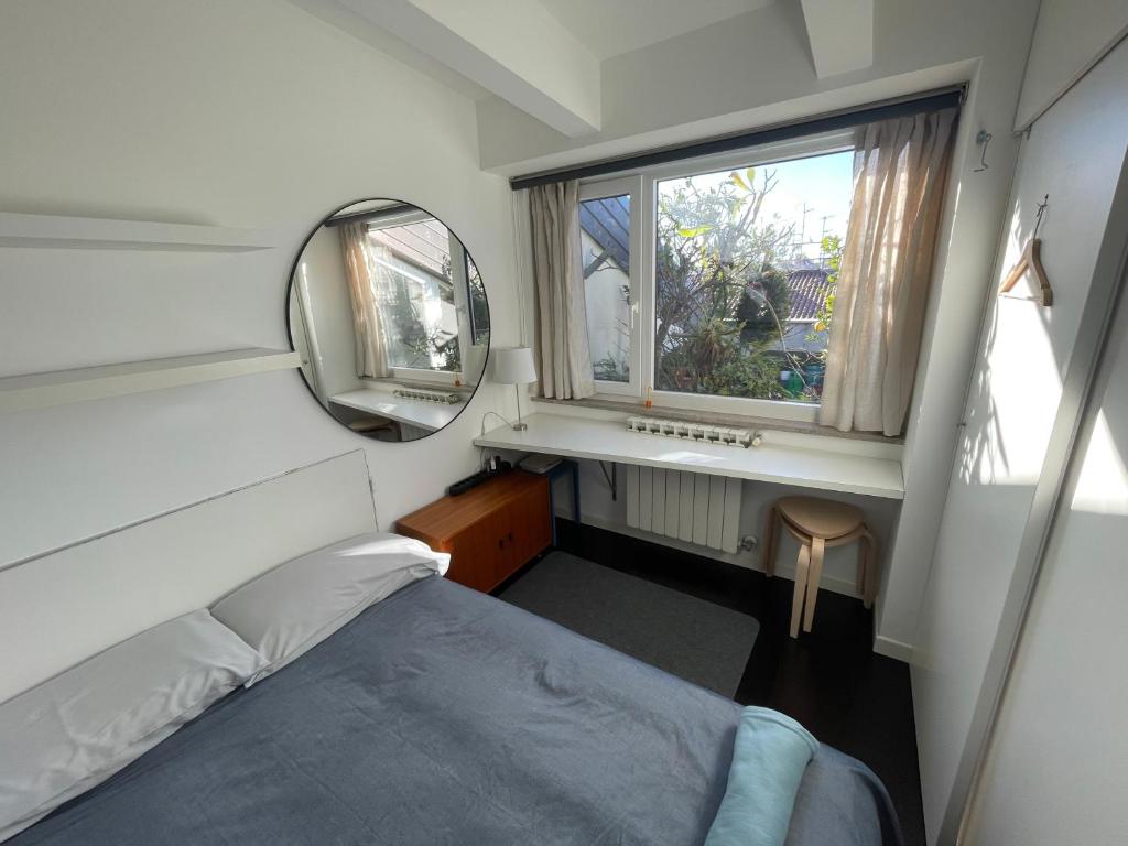 a small bedroom with a bed and a mirror at Piccola camera in appartamento condiviso con terrazza vista mare in Trieste