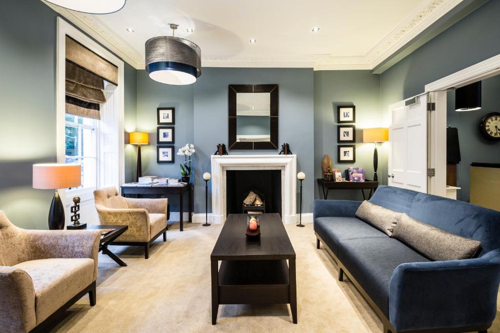 a living room with a blue couch and a fireplace at Montagu Place Hotel in London