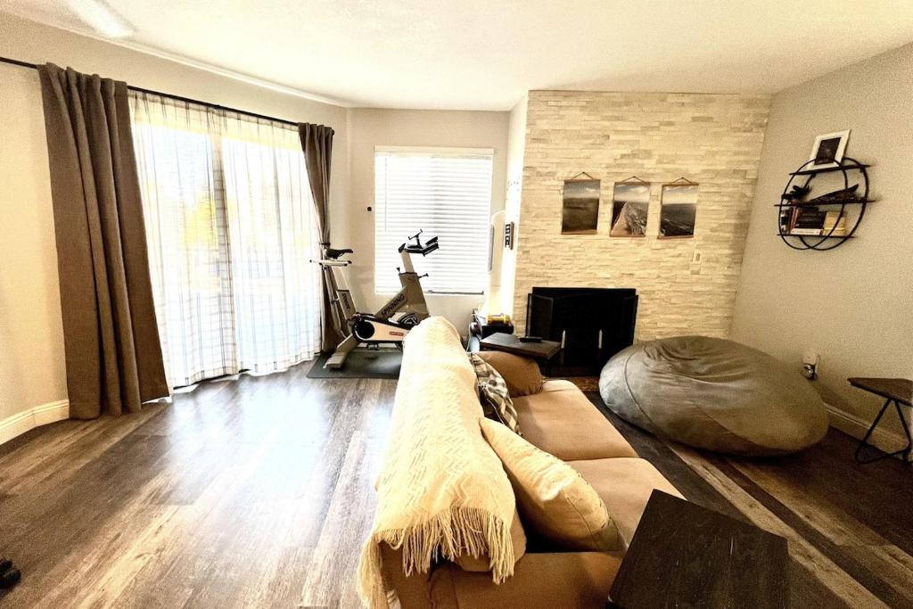 a living room with a couch and a fireplace at Sunny Retro Row Condo- Walk to Beach! in Long Beach