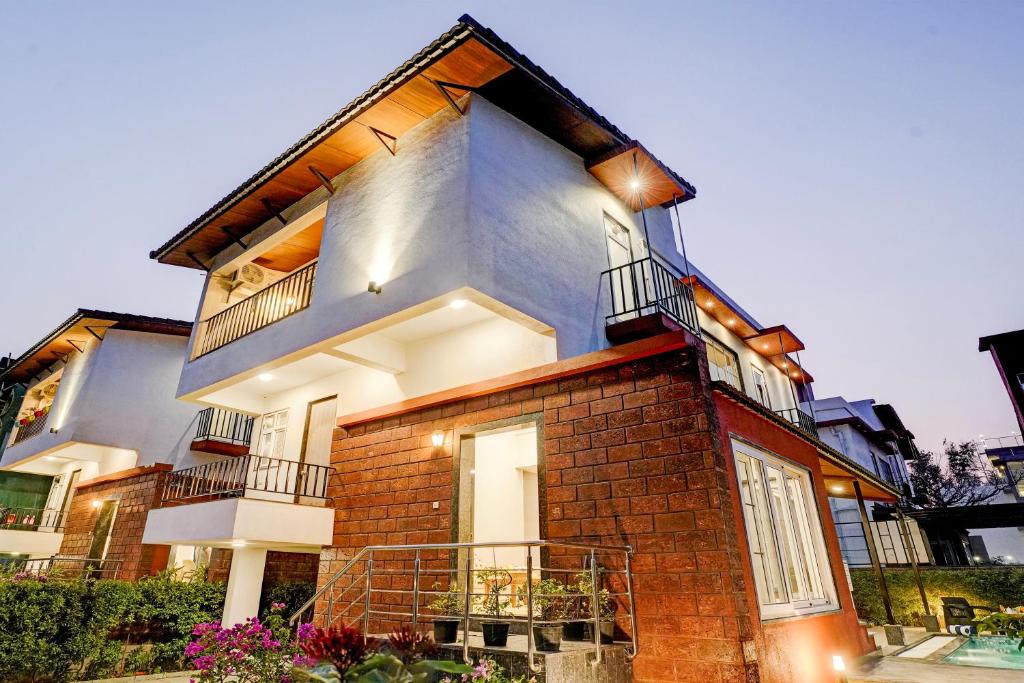 a large brick building with a balcony on it at ELIVAAS 3 BHK Aamy Villa with Pvt Pool & Garden in Lonavala