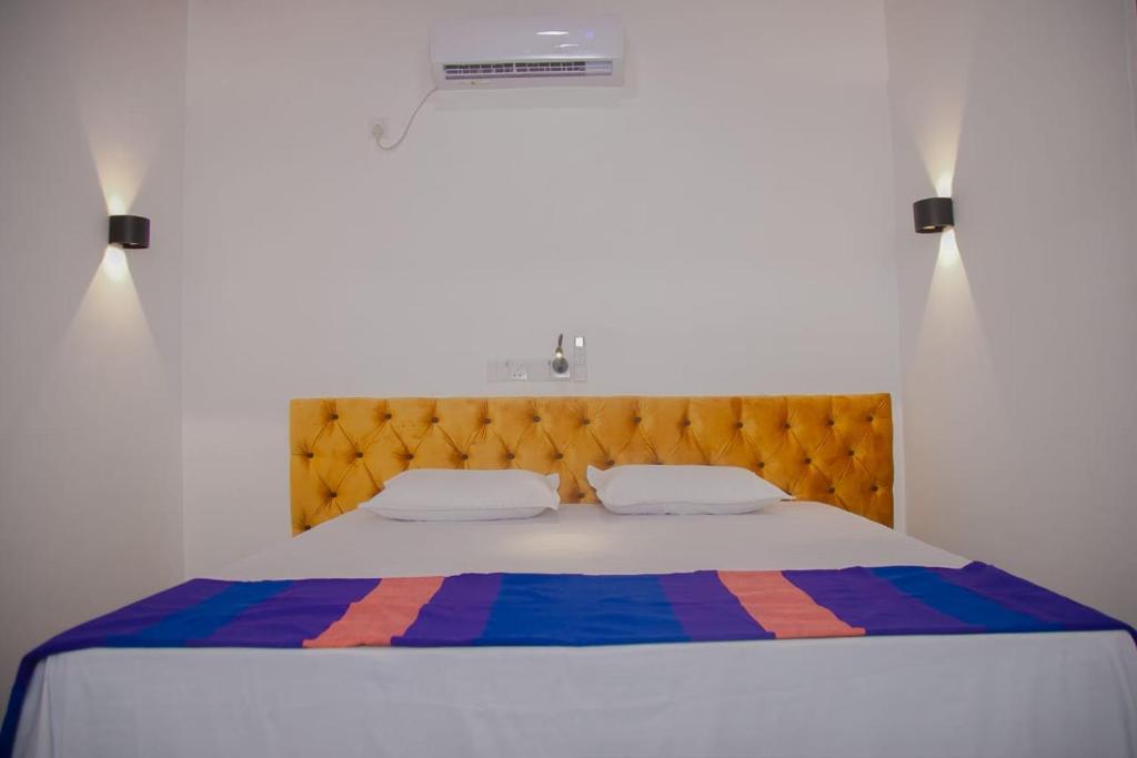 a bedroom with a large bed with a wooden headboard at Hill Top Heaven in Hikkaduwa