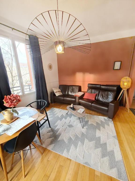 un salon avec un canapé et une table dans l'établissement La suite 21, 73 m2 de charme, Centre ville, à Dijon