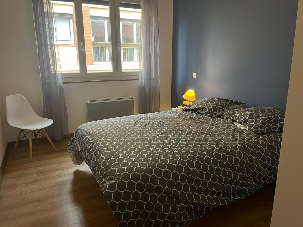 une chambre avec un lit, une chaise et une fenêtre dans l'établissement La Côte Pavée I T4, à Toulouse