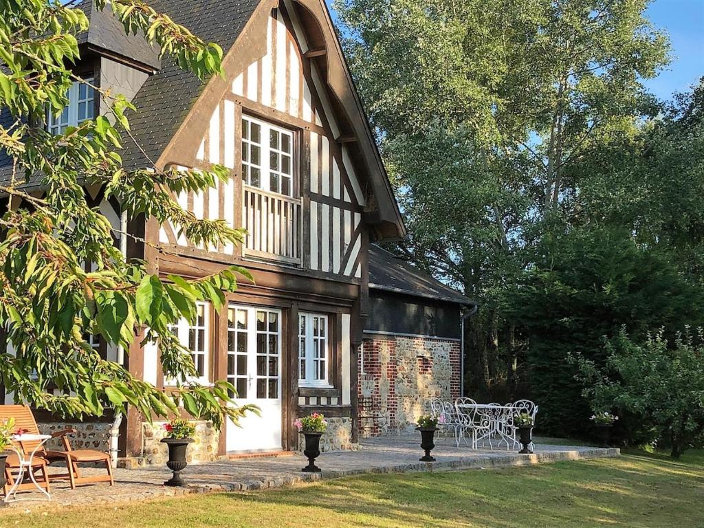 une maison avec un banc devant dans l'établissement Le Mont Roty - 15min Deauville - 15P, à Saint-Étienne-la-Thillaye