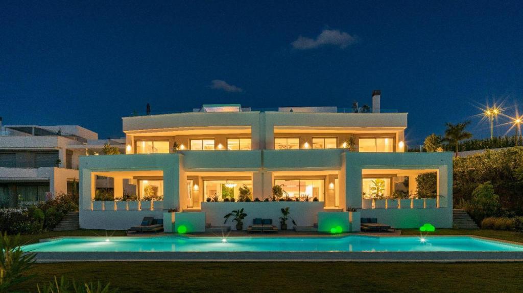 Una casa grande con piscina delante de ella. en Villa 11 Sunset, en Marbella