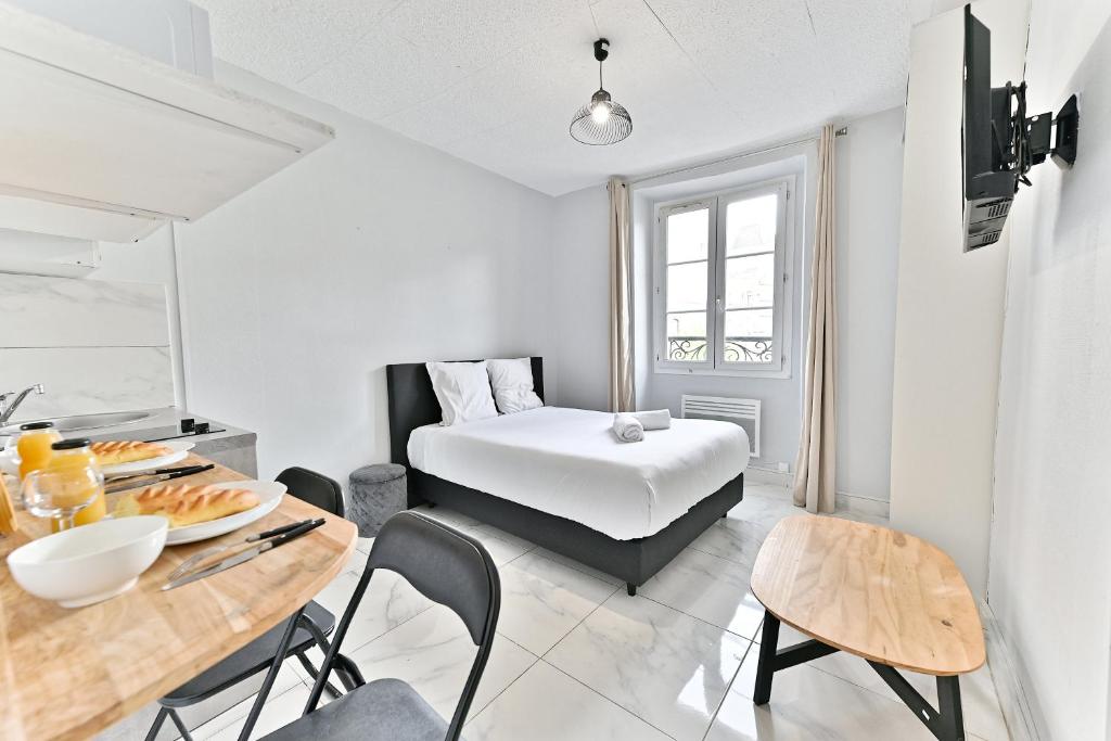 une chambre avec un lit, une table et des chaises dans l'établissement Montmartre - Studio Sacré Cœur - III, à Paris